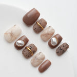 Brown and beige marble manicure with gold embellishments and pearls