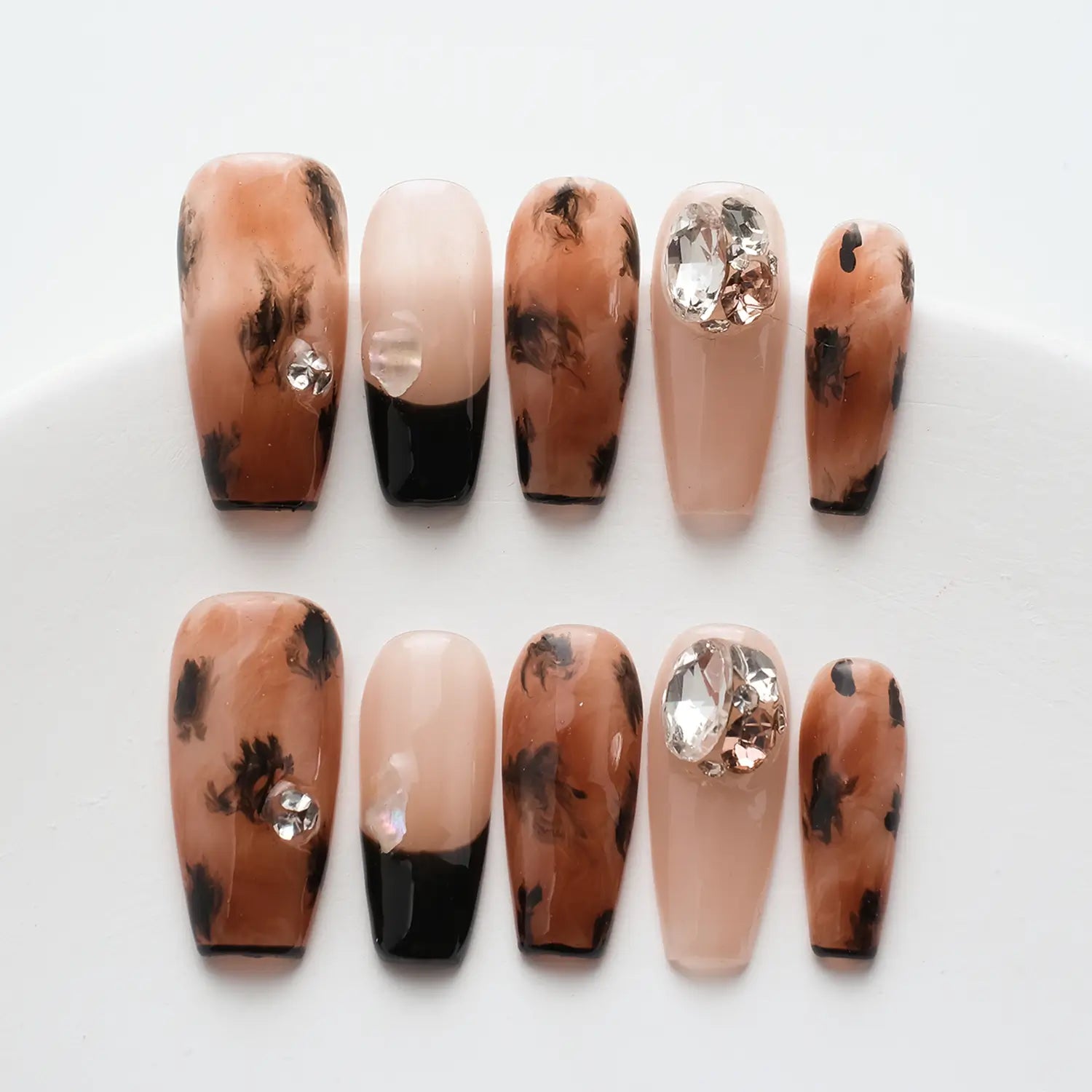 Close-up shots of 10 press-on nails, showing off their defined nail shapes and intricate designs.