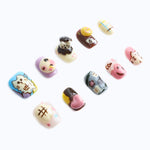 A playful cat design with pastel colors and press-on nails with a small ice cream cone and heart-shaped details