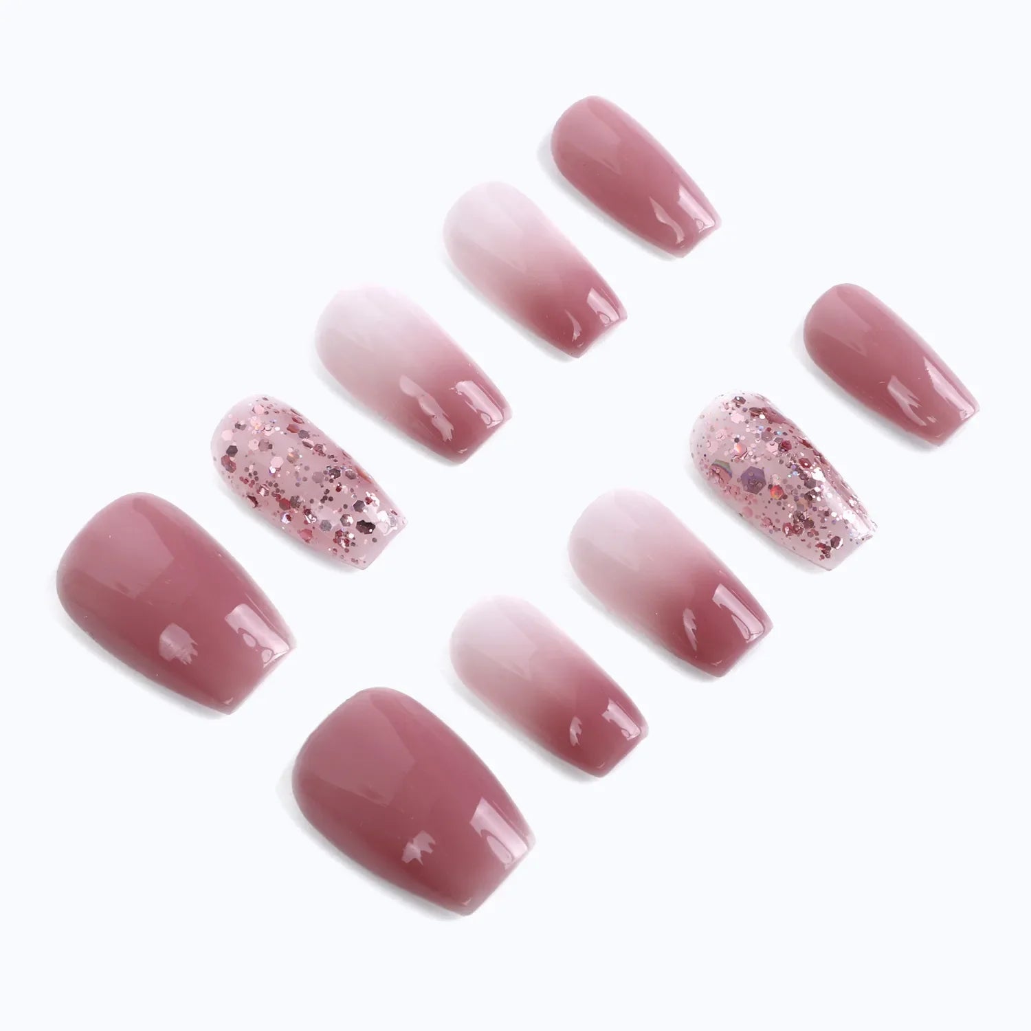 Press-on nails feature a soft rose nude color with gradient and glitter designs